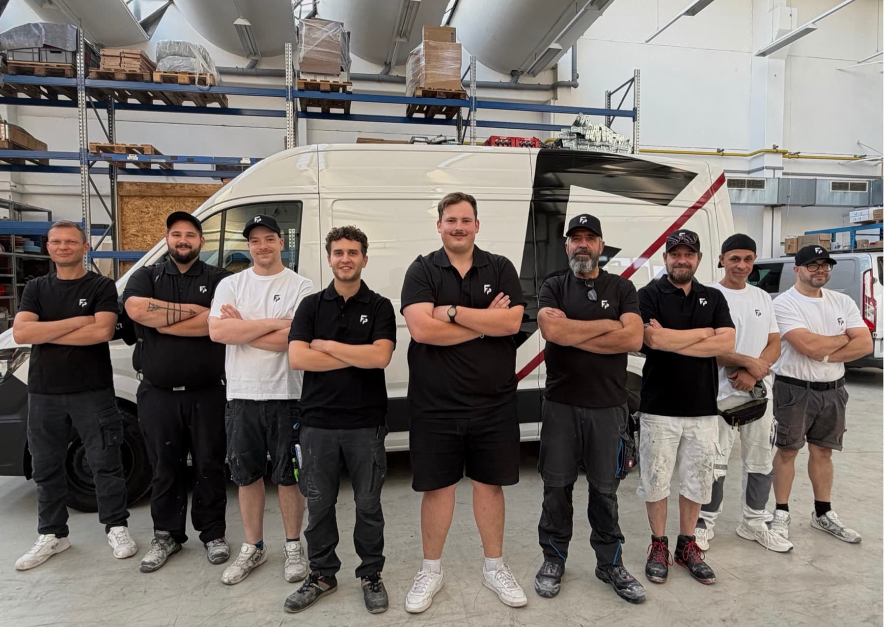 Die Mannschaft der Foor Projekt & Ausbau GmbH vor dem Firmenfahrzeug in der Halle in Ratingen